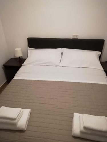 a large bed with white sheets and two white towels at Residenza Orsini in Benevento