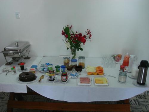 a white table with food and a vase of flowers at Casa Schneider in Gravatá