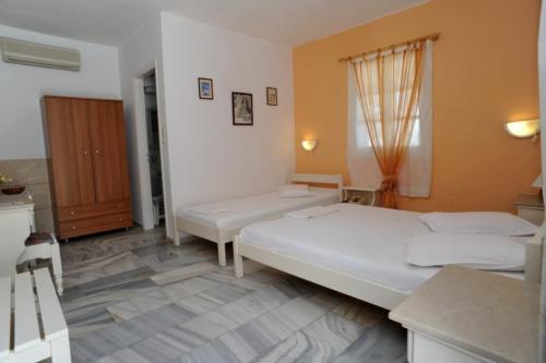 a bedroom with two beds and a window at Akrogiali Hotel in Agios Sostis