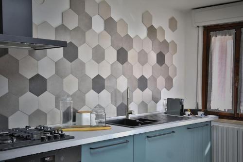 a kitchen with a checkerboard pattern on the wall at La Casa di Luna in Borghetto Lodigiano
