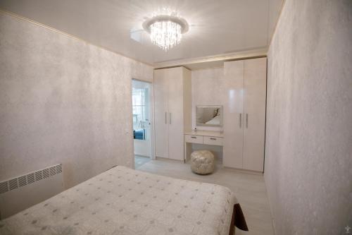 クロプィウヌィーツィクィイにあるApartments on Preobrazhenskayaのベッドルーム1室(ベッド1台、シャンデリア付)