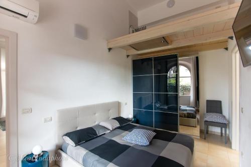 een slaapkamer met een kingsize bed en een spiegel bij La Suite di Bonnes Vacances in Pietrasanta