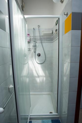 a shower with a glass door in a bathroom at Mansardine Metropolitane in Brescia