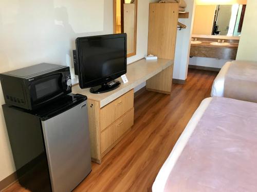 um quarto com uma cama e uma televisão e um quarto com uma cama gmaxwell gmaxwell em Sea-Tac Airport Value Inn em SeaTac