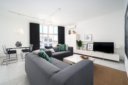 a living room with two couches and a tv at Beautiful Modern Apartment in Olhão, Algarve in Olhão