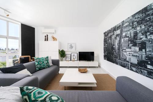 a living room with a couch and a tv at Beautiful Modern Apartment in Olhão, Algarve in Olhão