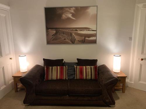 a living room with a couch and two lamps at Apartment 39c in Oban