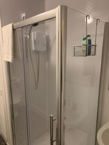 a shower with a glass door in a bathroom at Apartment 39c in Oban