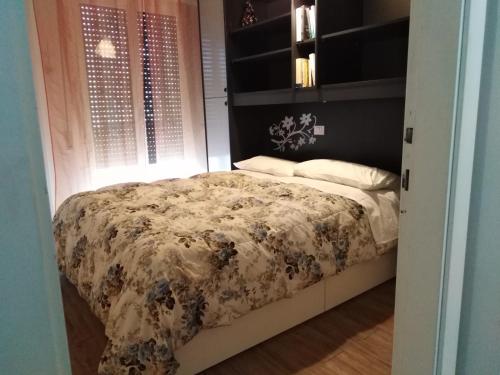 リミニにあるアパルタメント アメリカのベッドルーム1室(花柄の掛け布団付きのベッド1台付)