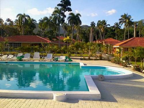 a large swimming pool with chairs and a resort at villa Clara in Los Róbalos