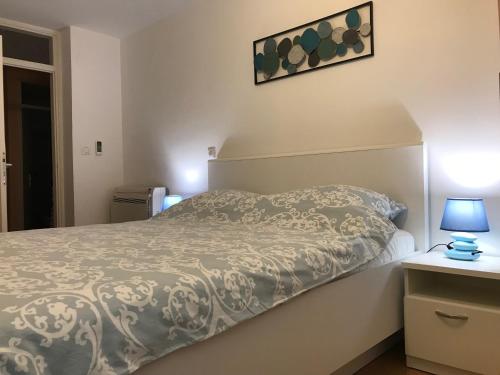 a bedroom with a bed and a lamp on a table at Apartments Milanović in Mali Lošinj