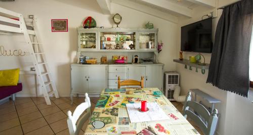 a dining room with a table and a kitchen at Mansardine Metropolitane in Brescia