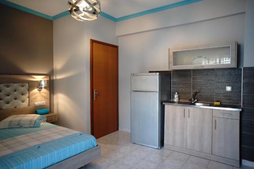 a small kitchen with a sink and a refrigerator at Blue Dream Hotel in Olympiaki Akti