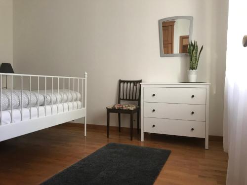 a bedroom with a crib and a dresser and a mirror at Holiday Flat Green Coast in Espinho