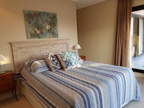 1 dormitorio con 1 cama con manta azul y ventana en Elegante departamento 2D en Yerba Buena