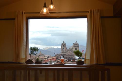 a window with a view of a city at Nao Victoria Hostel in Cusco