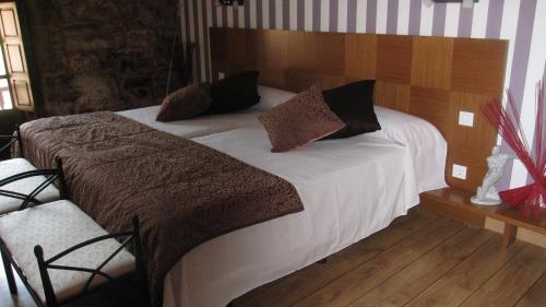 a bedroom with a large bed with a wooden headboard at Posada Ormas in Ormas