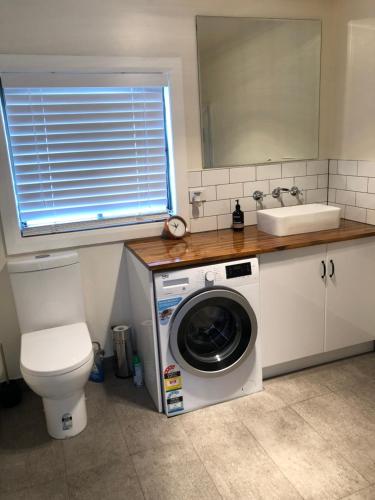 a bathroom with a washing machine and a sink at Apartment 5ive in Devonport