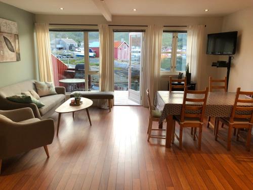 a living room with a couch and a table at Ballstad Brygge Rorbu in Ballstad