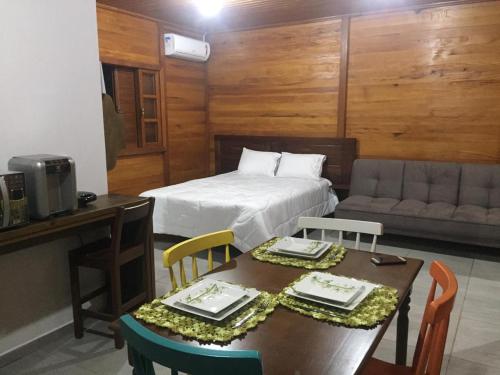a bedroom with a bed and a table and chairs at Caminhos da Serra do Tabuleiro - Chalé Araucária in São Bonifácio