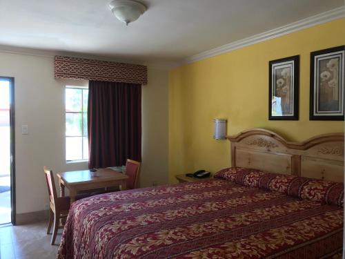 a hotel room with a bed and a table and a window at El Rancho Dolores at JT National Park in Twentynine Palms