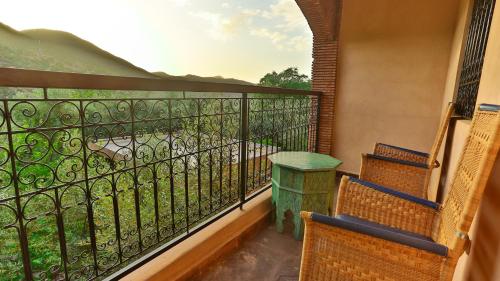 a balcony with two chairs and a table at ferme by Ikalimo in Ourika