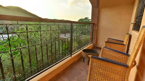 a balcony with two chairs and a view of a yard at ferme by Ikalimo in Ourika