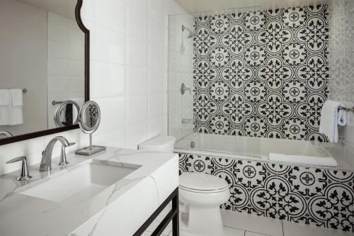 a white bathroom with a toilet and a shower at La Valencia Hotel in San Diego