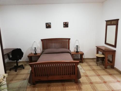 a bedroom with a bed and two tables and a mirror at Hostal Centro de Coyoacan in Mexico City