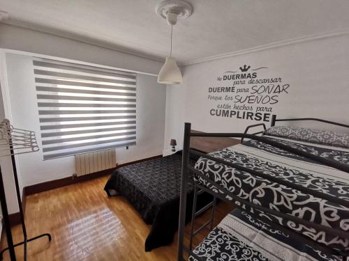 ein Schlafzimmer mit zwei Einzelbetten und einem Fenster in der Unterkunft Apartamentos Avenida de la paz 2 in Logroño