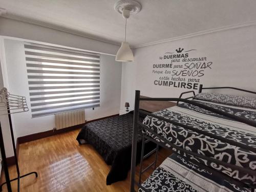 a bedroom with two twin beds and a window at Apartamentos Avenida de la paz 2 in Logroño