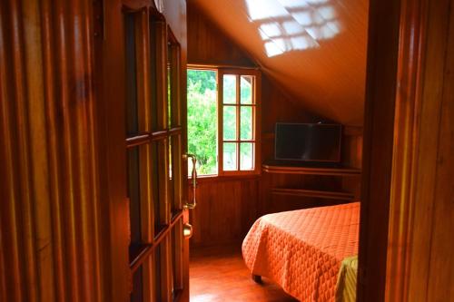 an attic bedroom with a bed and a window at QUINTA PRIMAVERA - Hostería Campestre in Nueva Loja