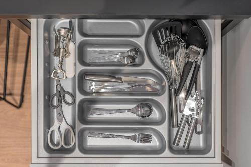 a metal drawer filled with utensils in a kitchen at HaPPy Inn GOLD Studio, self check-in, Parking in the underground garage in Vilnius