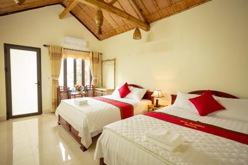 a bedroom with two beds with red and white sheets at Tam Coc Paradise Homestay in Ninh Binh