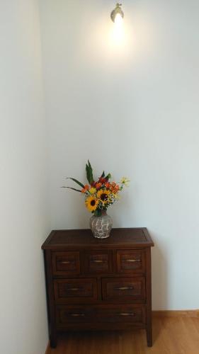 a vase of flowers sitting on top of a dresser at Okunikko Guesthouse JUN in Nikko