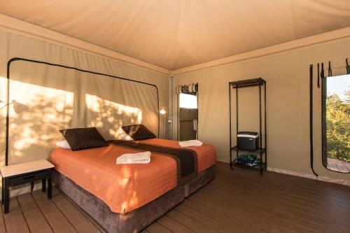 a bedroom with a bed and a large window at Eco Beach Wilderness Retreat in Broome