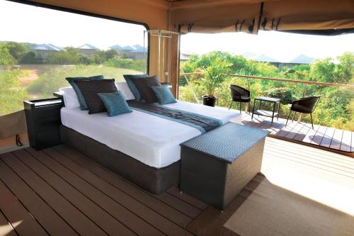 
a hotel room with a bed and a balcony at Eco Beach Wilderness Retreat in Broome
