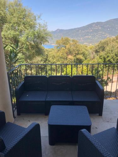 a couch sitting on a balcony with a view at Appartement Tissoggio in Propriano