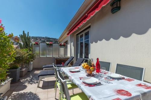 une table et des chaises sur le patio d'une maison dans l'établissement LE MANTEGA - F2 MODERNE,CENTRE VILLE, 2 GRANDES TERRASSES,CLIMATISATION, ASCENSEUR, à Nice