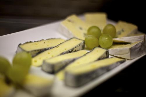 a plate of cheese and grapes on a table at Kinder- & Gletscherhotel Hintertuxerhof in Tux