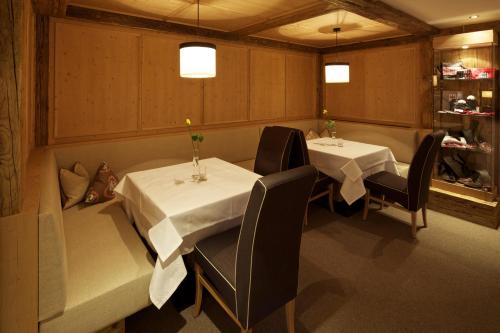 a dining room with two tables and chairs in a restaurant at Kinder- & Gletscherhotel Hintertuxerhof in Tux