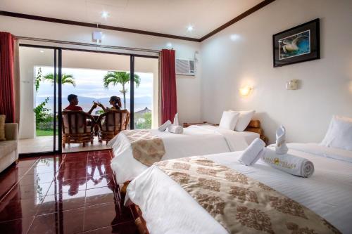 莫阿爾博阿的住宿－Kasai Village Dive Resort，两间带两张床的酒店客房 - 两人坐在椅子上