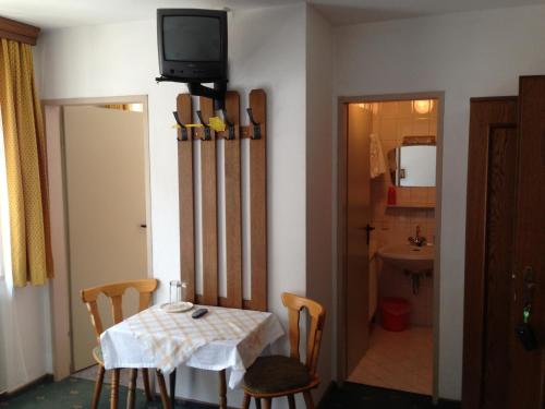ein Esszimmer mit einem Tisch und einem TV an der Wand in der Unterkunft Haus Tenk in Mittersill