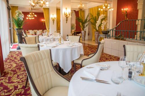 a dining room with white tables and chairs at Best Western Beauséjour in Lourdes