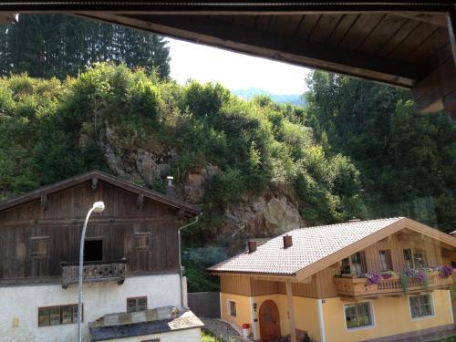 a house and a barn in front of a mountain at Haus Tenk in Mittersill