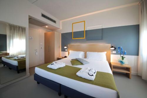 a bedroom with a large bed with towels on it at Best Western Hotel Cristallo Mantova in Virgilio