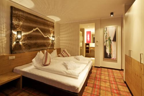 a bedroom with a large bed in a room at Kinder- & Gletscherhotel Hintertuxerhof in Tux