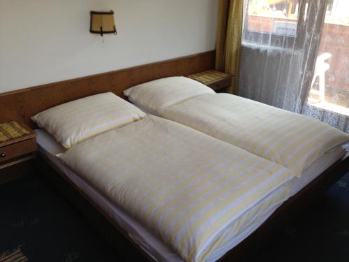two beds sitting next to a window in a bedroom at Haus Tenk in Mittersill