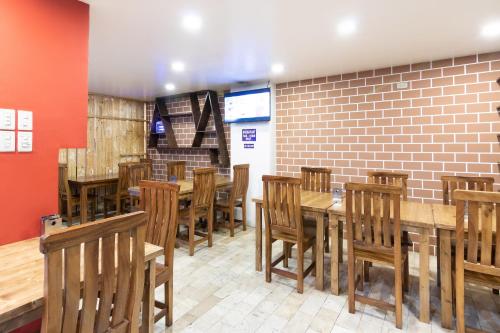a restaurant with wooden tables and chairs and a brick wall at OYO 175 Hotel Elegant in Baguio