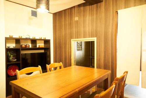 金澤的住宿－Nagomi TABI-NE，一间带木桌和椅子的用餐室